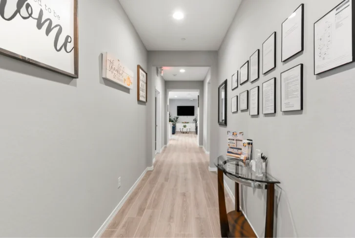 Hallway lined with framed artwork at Sunrise Haven Senior Homes