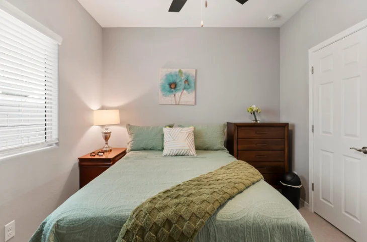 Resident bedroom with a full bed and green bedding at Sunrise Haven Senior Homes